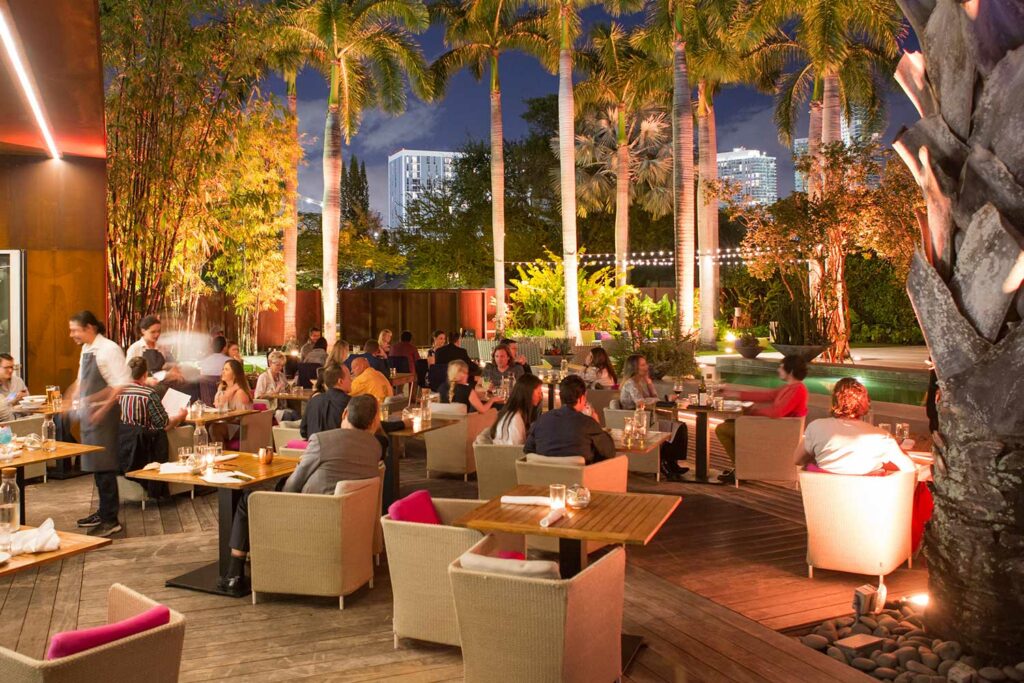 The Sacred Space Miami with  and outdoor patio surrounded by palm trees.