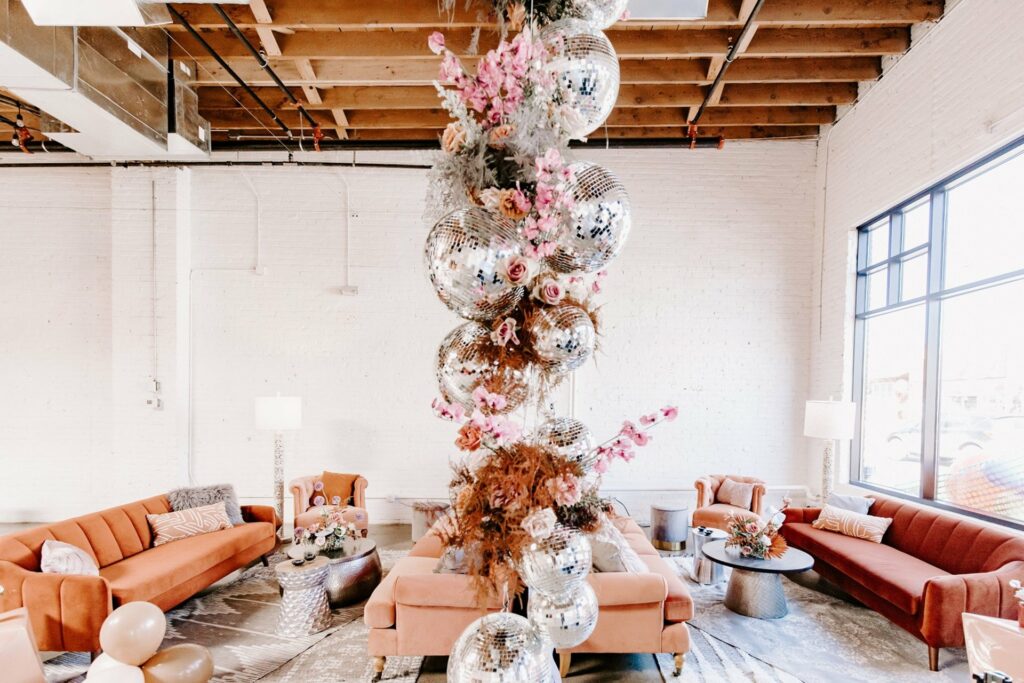 Venue with orange couches and hanging disco balls ceiling installation
