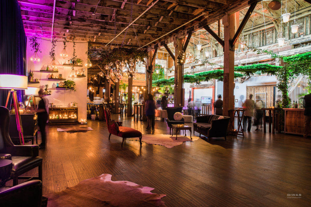 Sodo Park Seattle conference venue space with colorful lighting an ceiling greenery installations