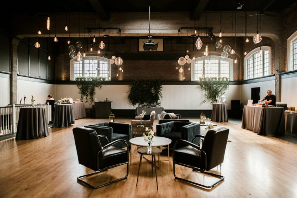 Venue space with black chairs and hanging light fixtures