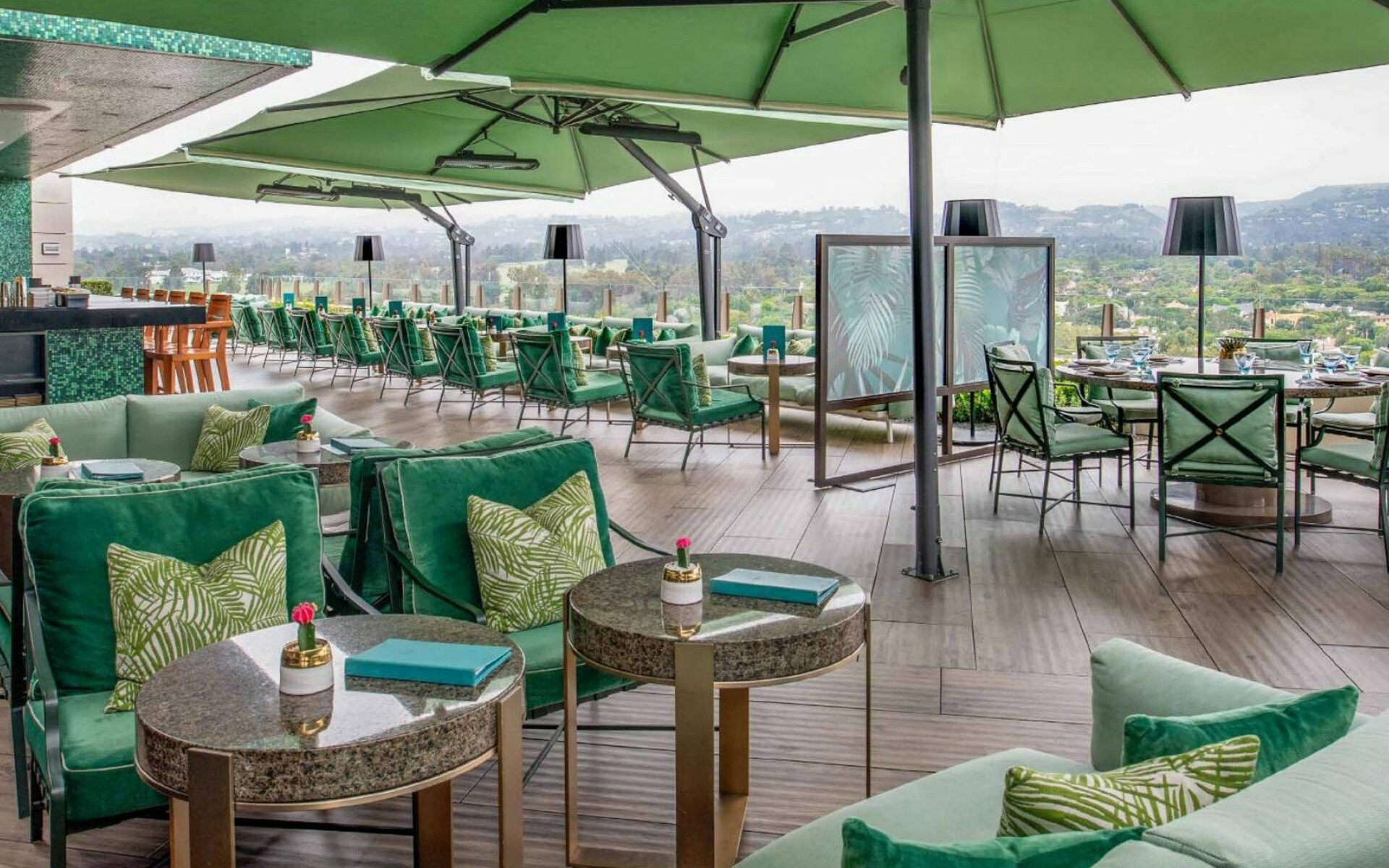 The Rooftop by JG outdoor patio area with green umbrellas and furniture 