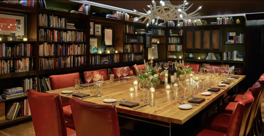 Urban farmer private dining room with red chairs and wooden table in library