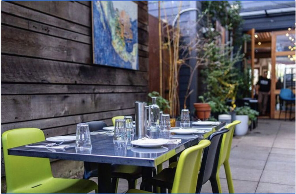 private dining table with bright green chairs outside on patio