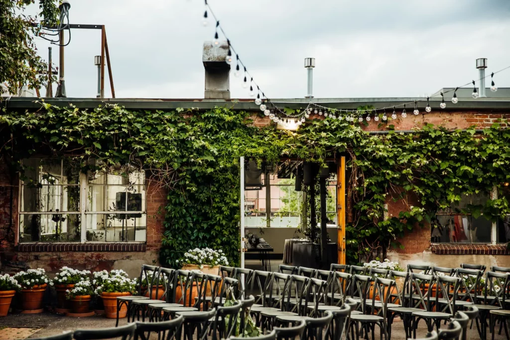 Outdoor venue with green vine walls and string lights