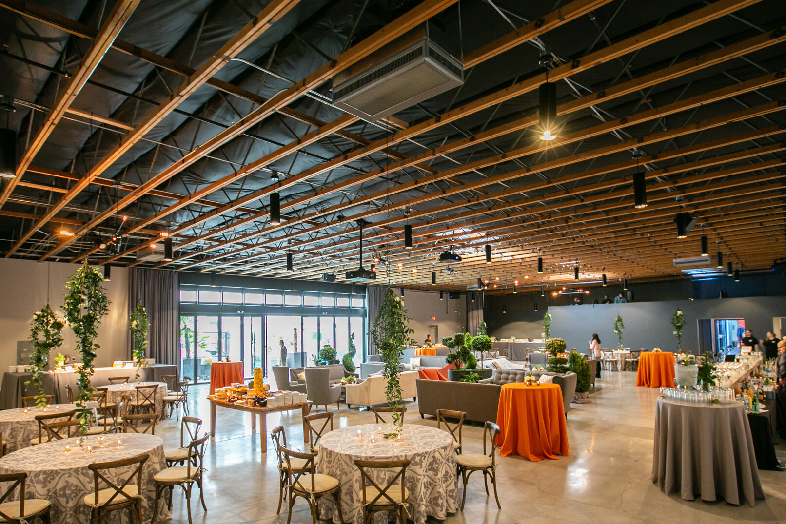 Large venue space with dining tables with orange table cloth