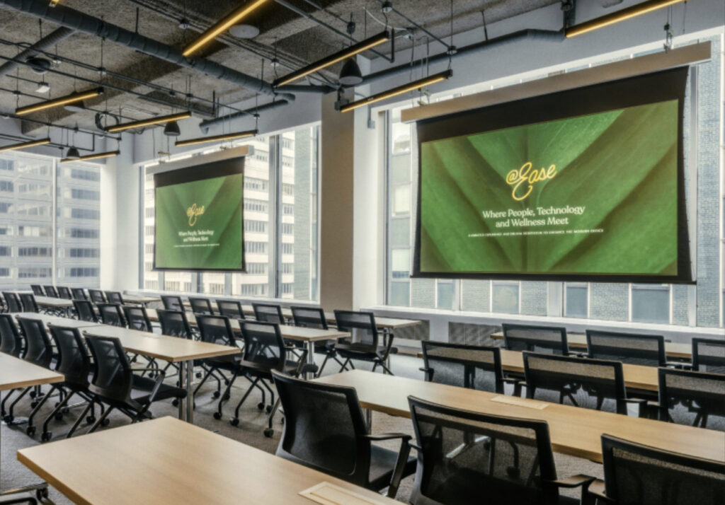 Long tables with office chairs facing large projector screens