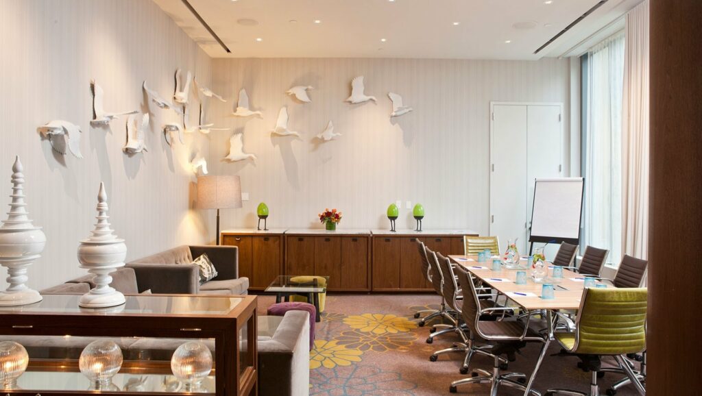 Stylish meeting space with colorful carpet and white artistic birds on the wall