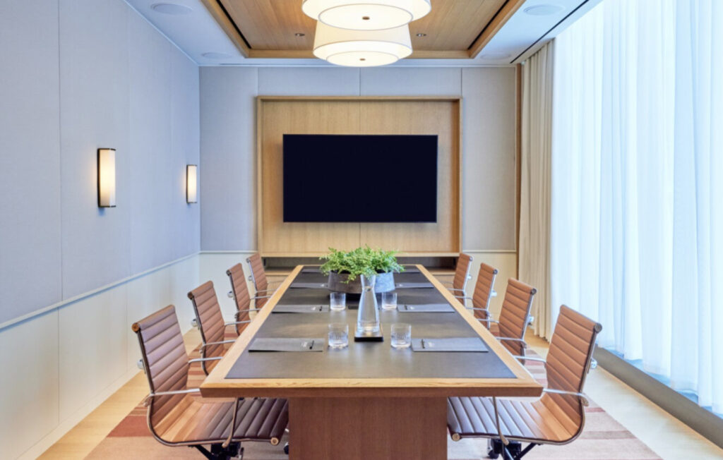 A light-filled boardroom with leather chairs and long conference table