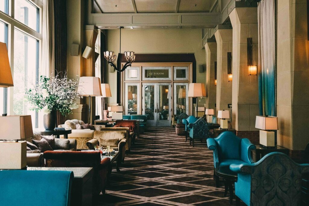 Inside of Soho Grand Hotel with tall ceilings and teal chairs