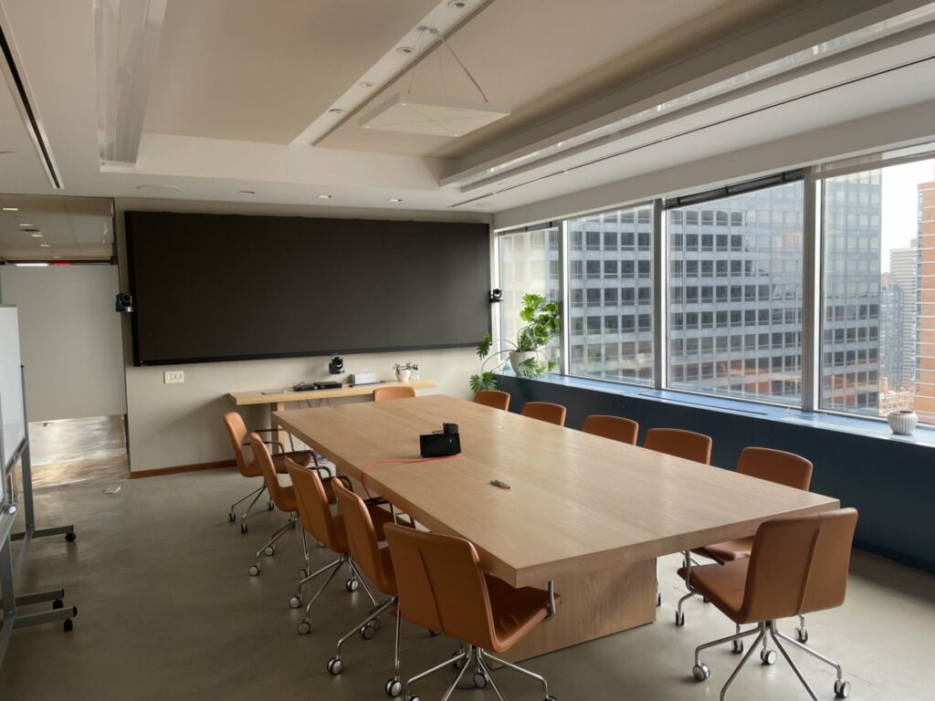 Room with large wooden conference table with a city view