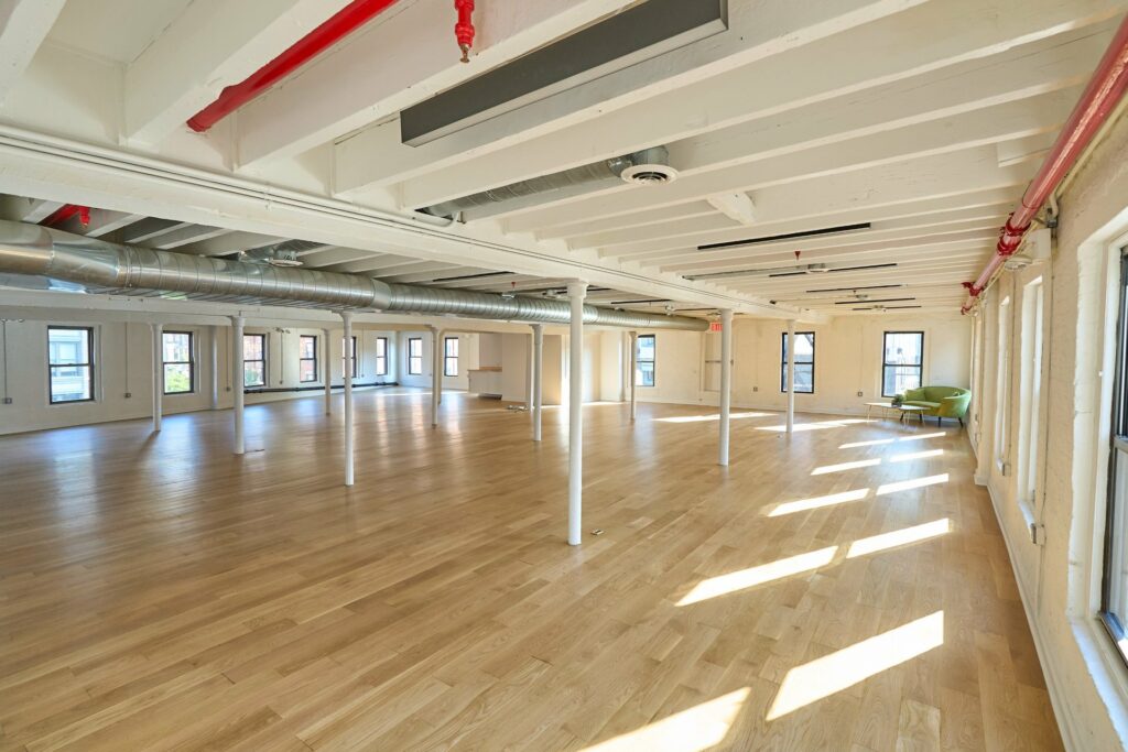 Large open event space with wooden floors and exposed beam ceilings 