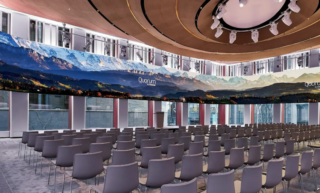 Large venue space with dozesn of chairs and an expansive ceiling 