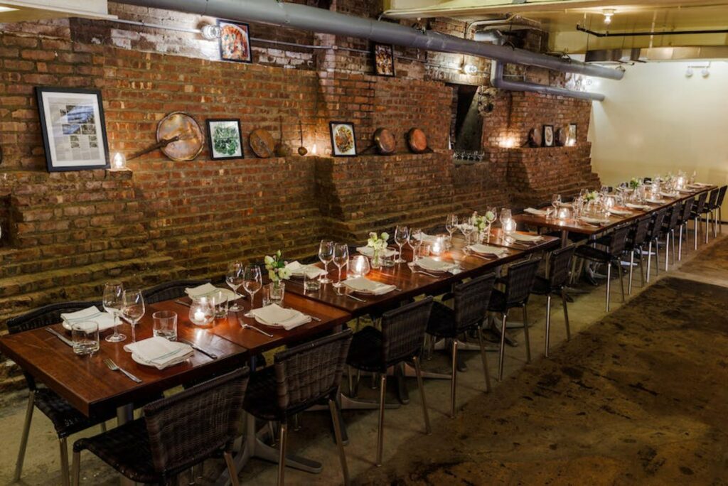 Private dining room with a brick accent wall and several dining tables