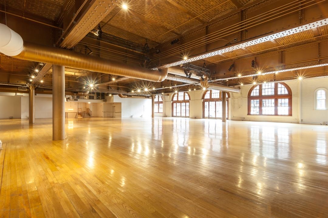 open event space with wooden floorings and brick ceiling