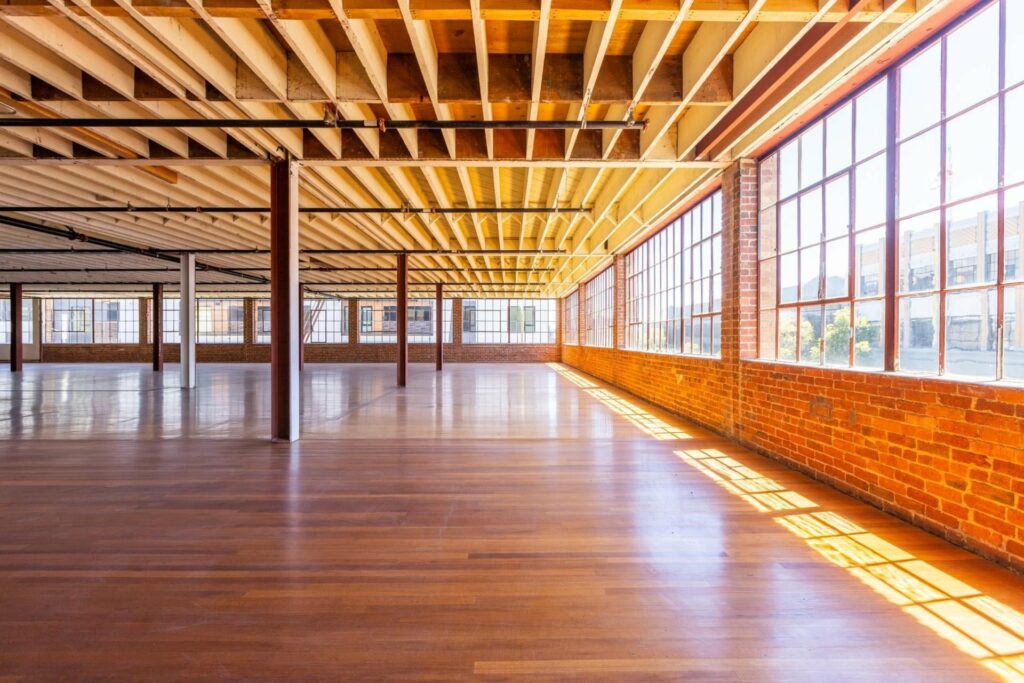 Expansive venue with wooden floor and large framed windows