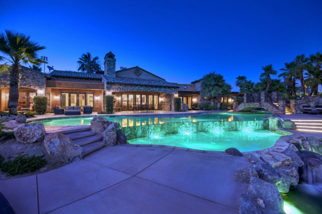 a pool at night surrounded by rocks at a Coachella event venue
