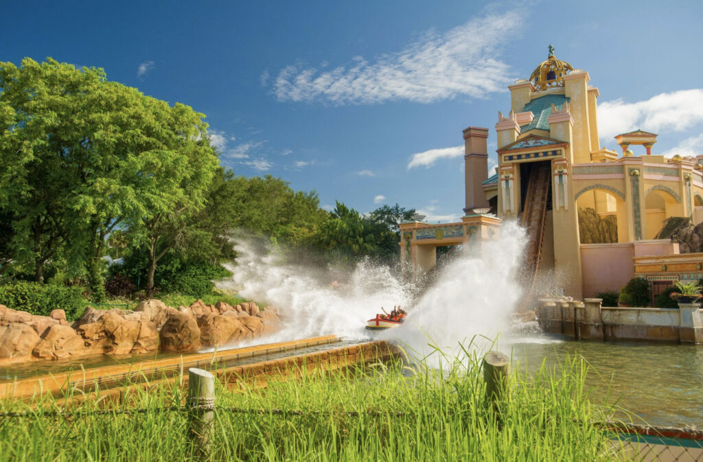 Sea World Orlando water slide through a yellow castle with water spraying in the trees 