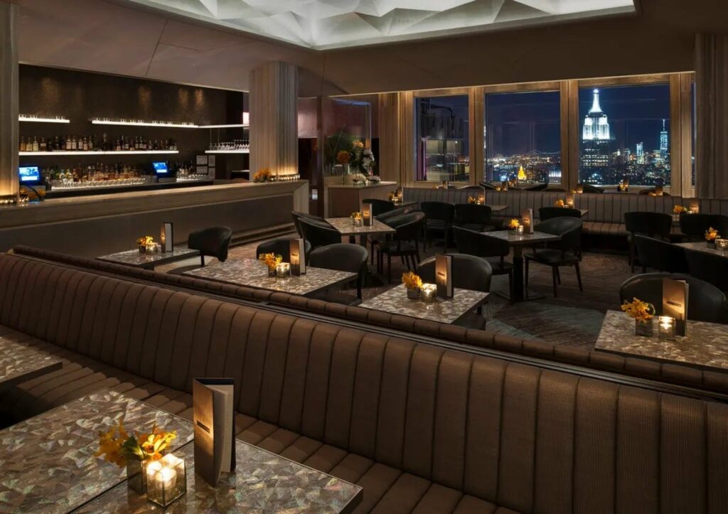 Tan luxurious lounge and tables overlooking the empire state building 