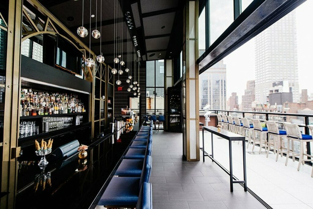 indoor/outdoor bar space overlooking the city with navy furniture and gold accents