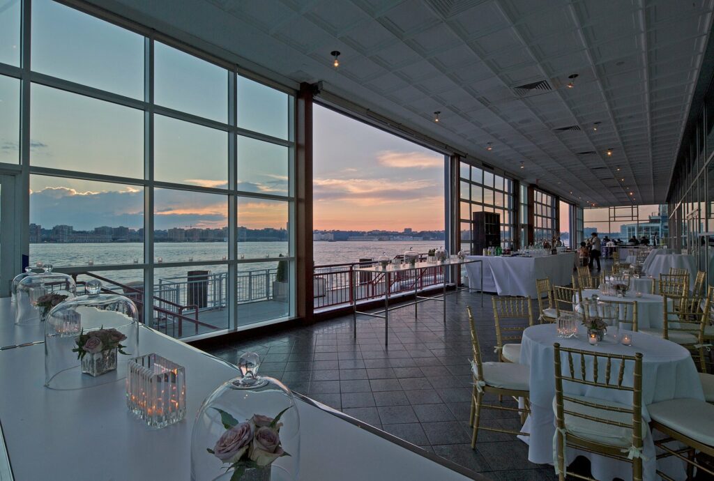 Sunset on the water with white linen tables and gold chairs