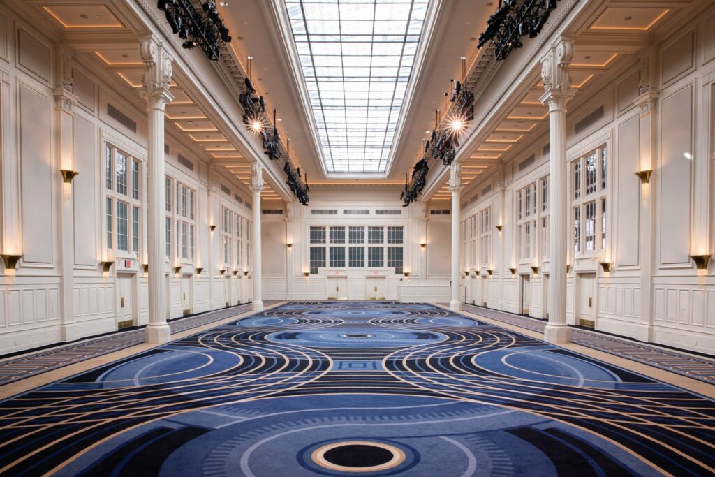 Grand ballroom with blue carpet and white pillars 