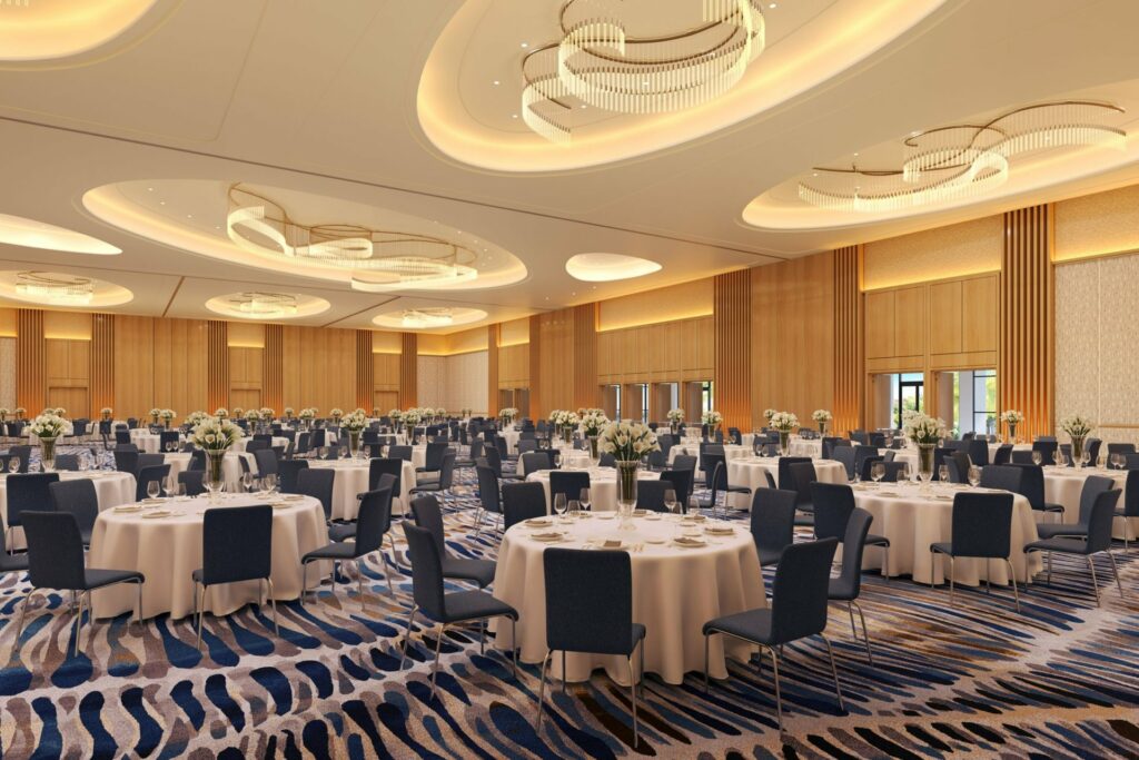 Conrad Orlando ballroom even space with blue, modern ceiling lighting, and white carpet and circular tables with navy chairs set up for a banquet