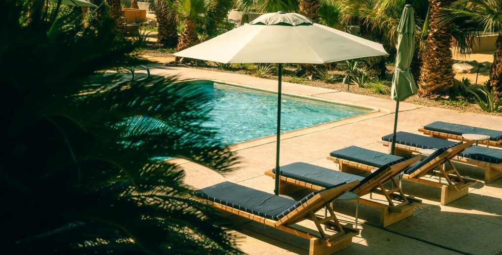 a pool with lounge chairs and umbrella
