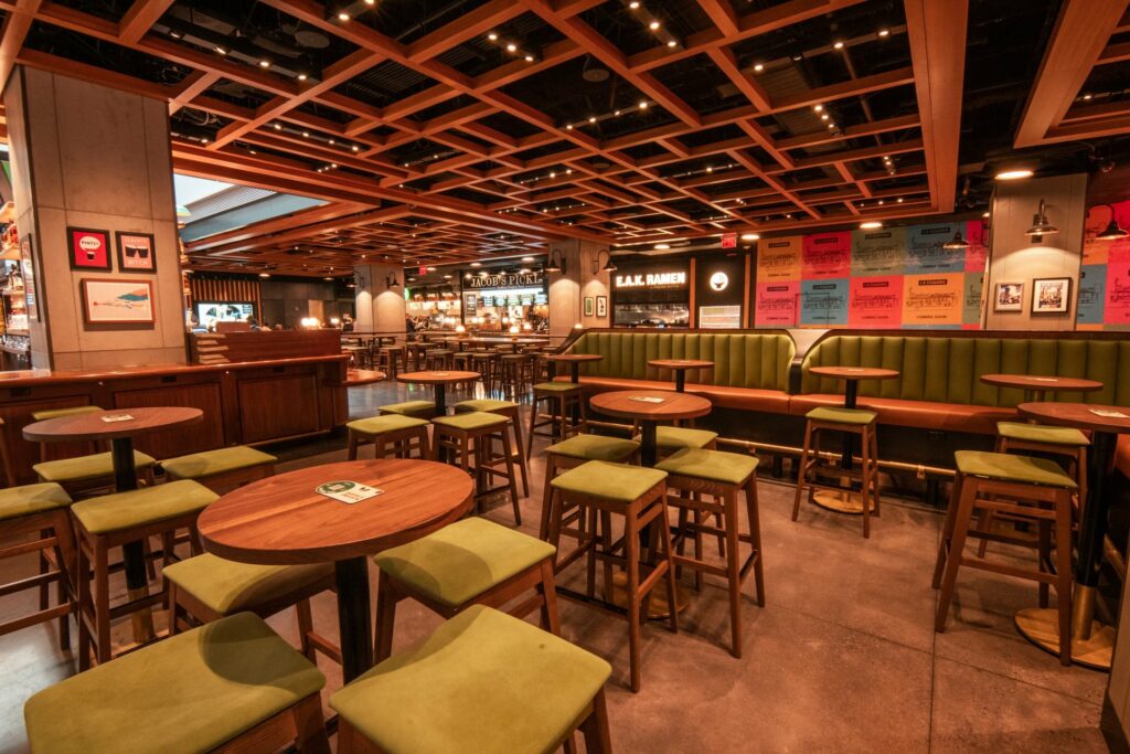 Colorful bar with green stools and wood tables and graphics on the wall