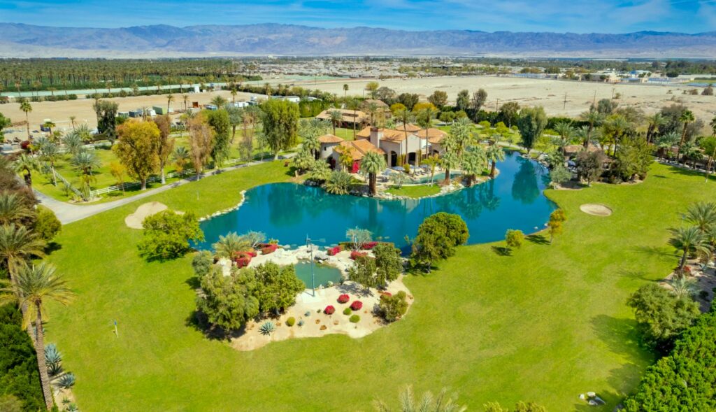 a pool surrounded by trees and buildings at a Coachella event venue
