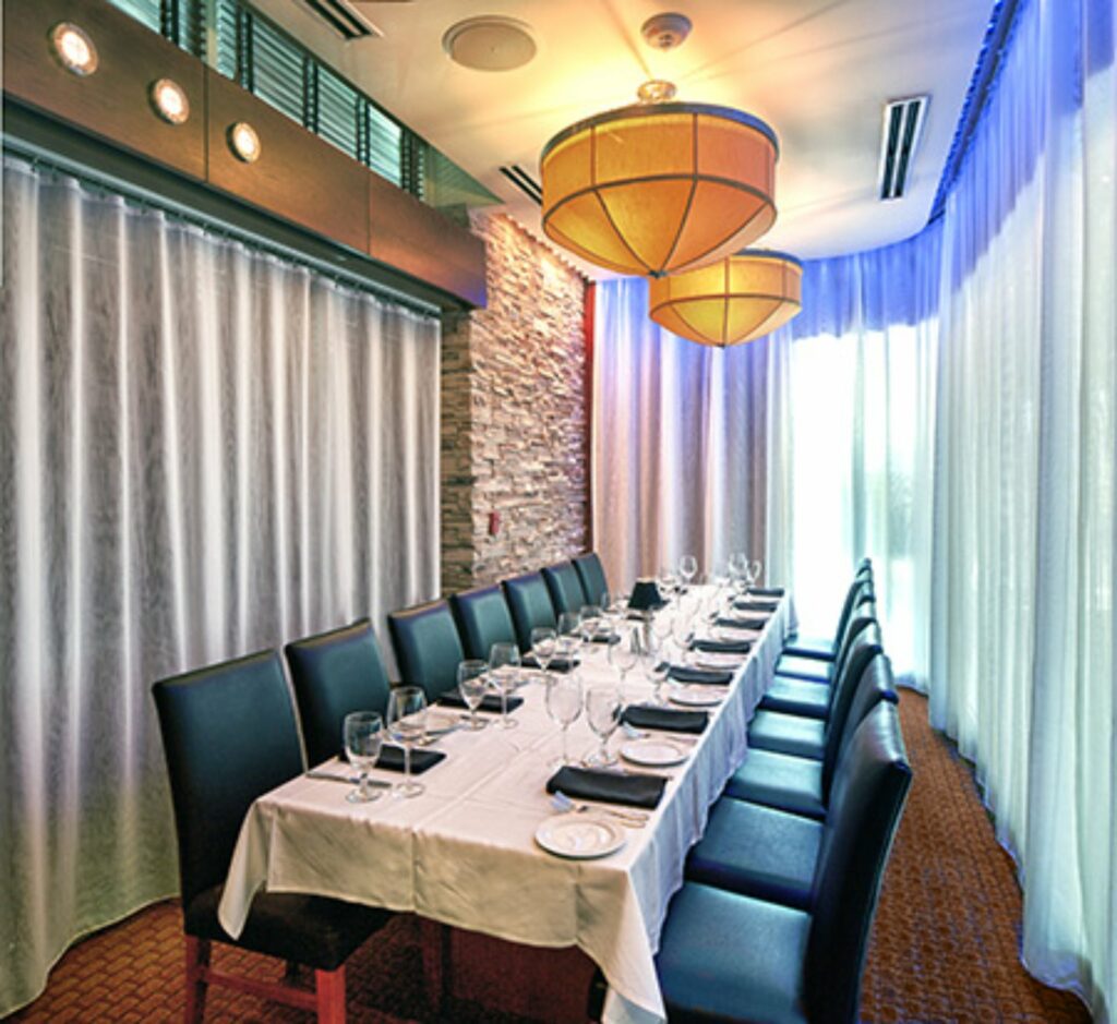 a private dining room in Orlando with a long table set for a dinner party
