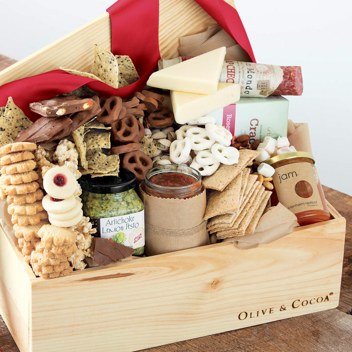 A wooden gift box overflowing with pretzels, cheese, chips, and snacks
