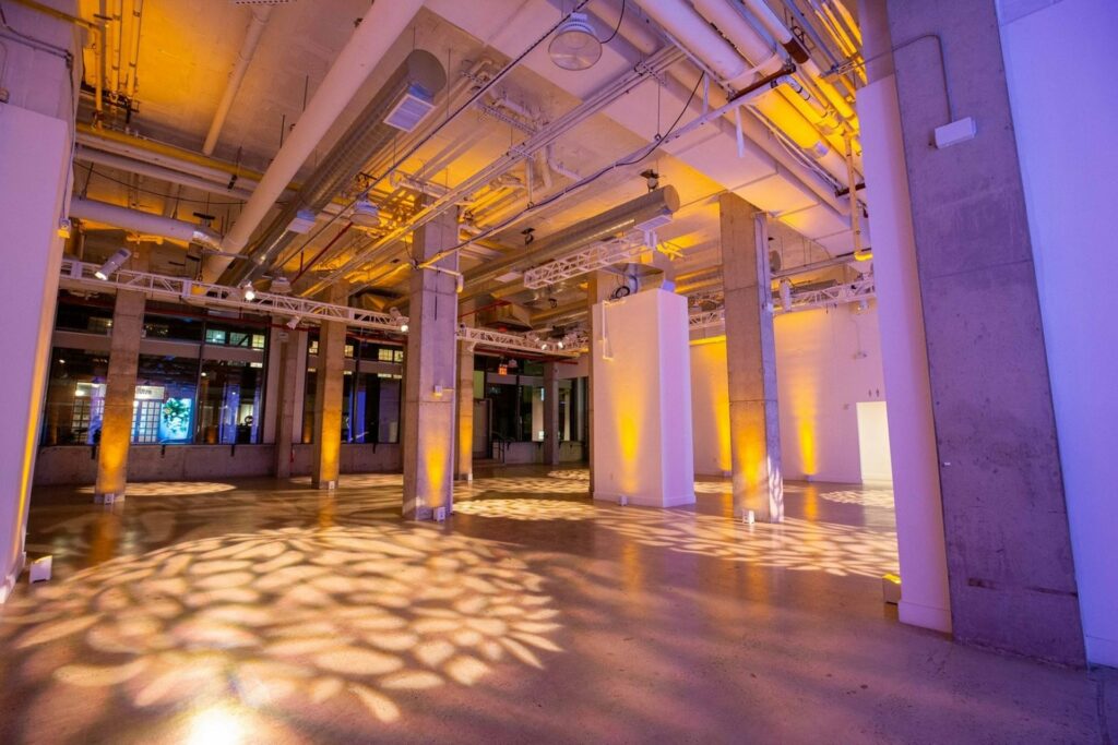 Large industrial venue with exposed ceilings and decorative lights on the floor