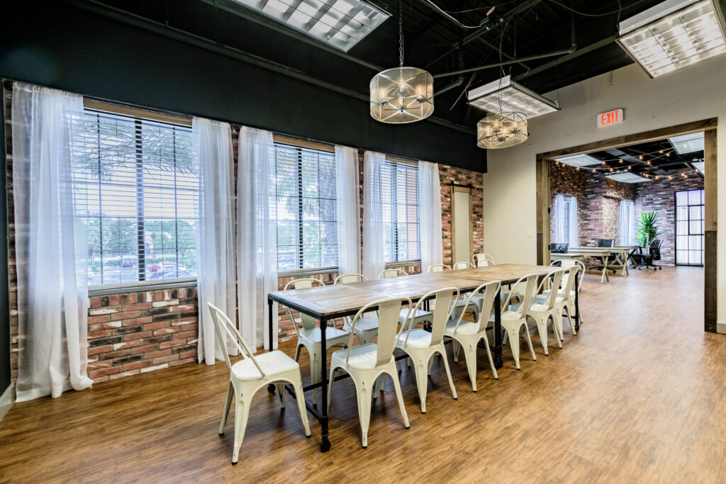 An event space with exposed ceiling, brick walls and natural lighting