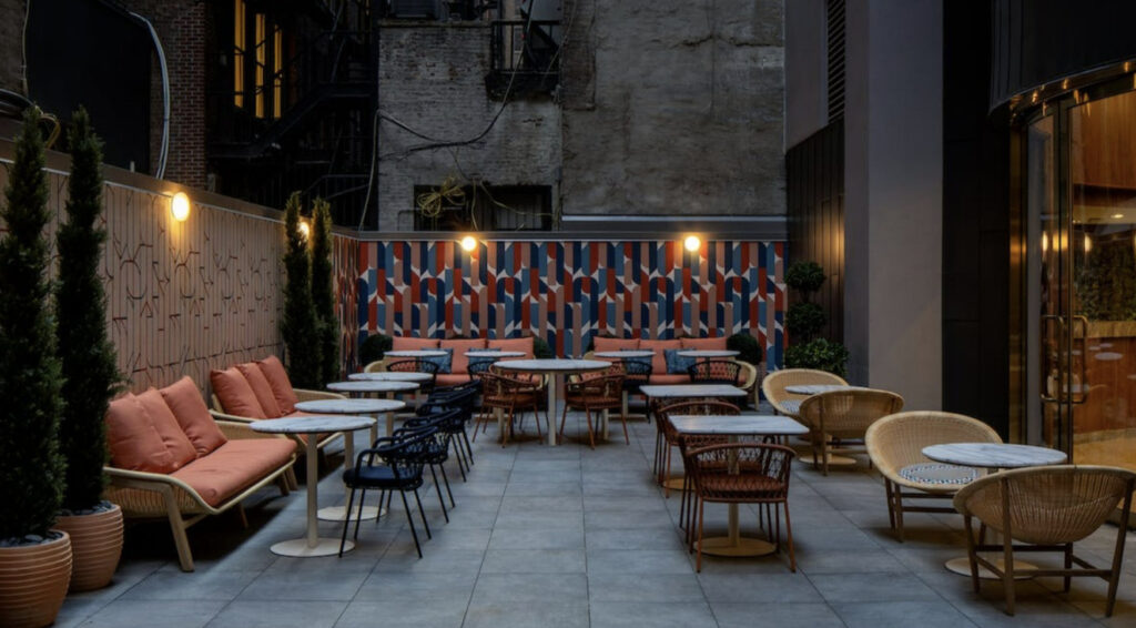 Harta in midtown Manhattan - a courtyard with marble tables and wicker chairs and orange couches