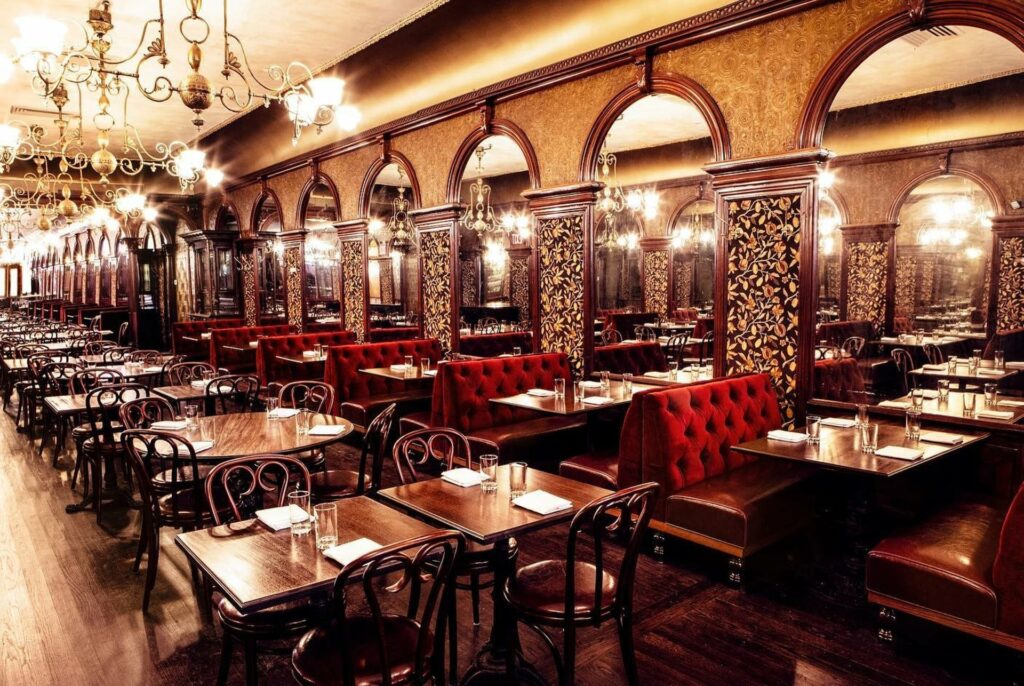 Gage and Tollner in Brooklyn with ornate details, red velvet benches and sconce lighting.