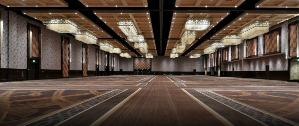 A large empty ballroom with plenty of chandeliers offering good lighting inside the venue