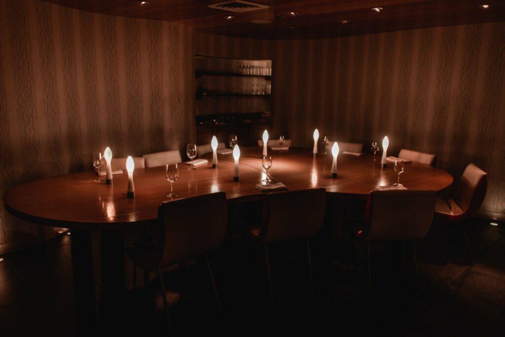 A dim private dining room with bean-shaped table 