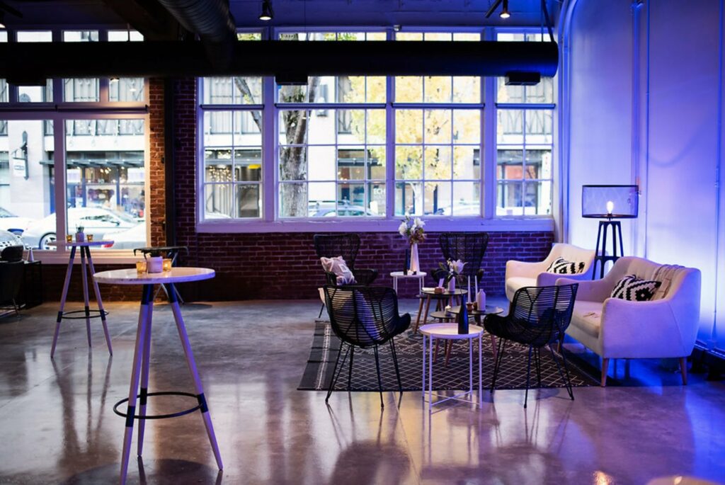 An event space with large windows, exposed wall bricks and a cozy furnitures