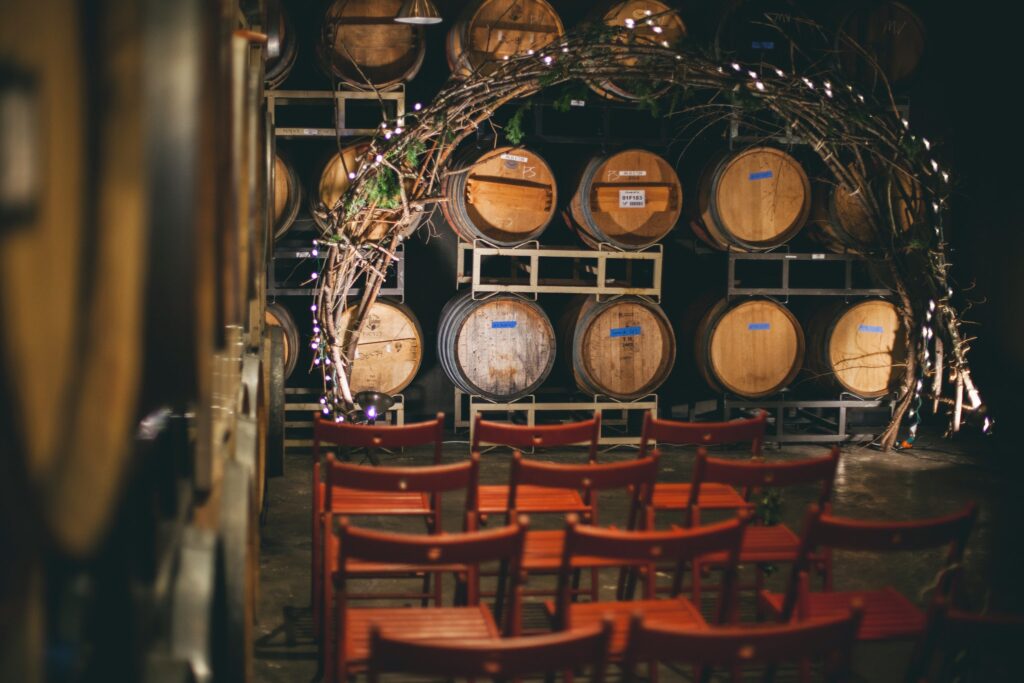 An event room with with barrels displayed on the side and a few light fixtures