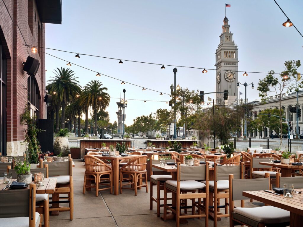 An outdoor patio with an overlooking views of the clock tower at the Port of San Francisco