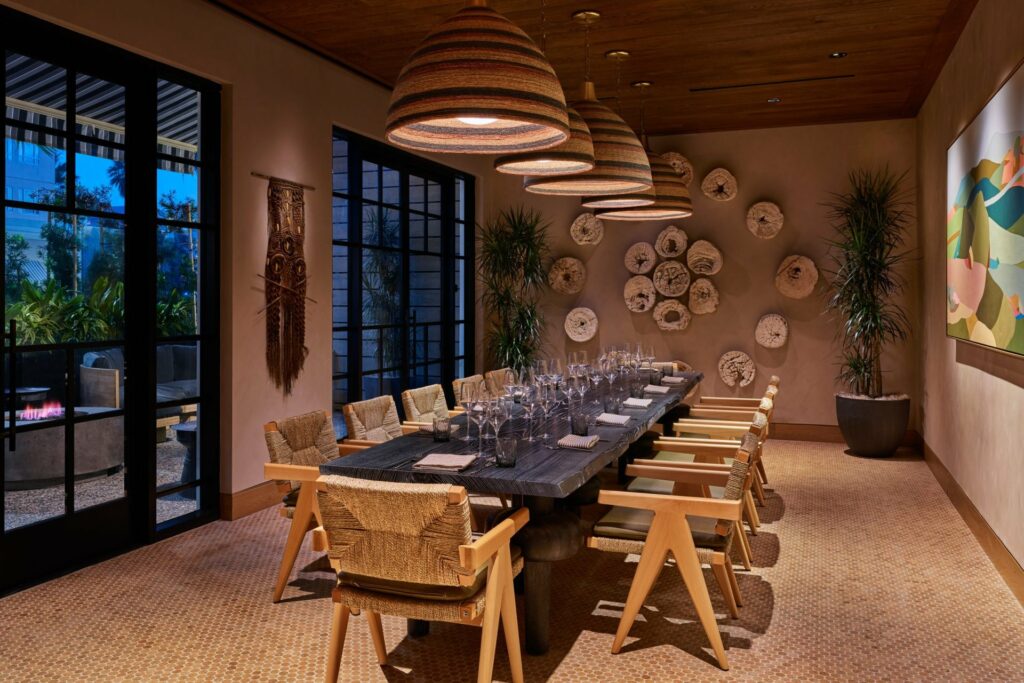 A private dining room with a touch of bohemian vibe fixtures, windows and access to outdoor patio