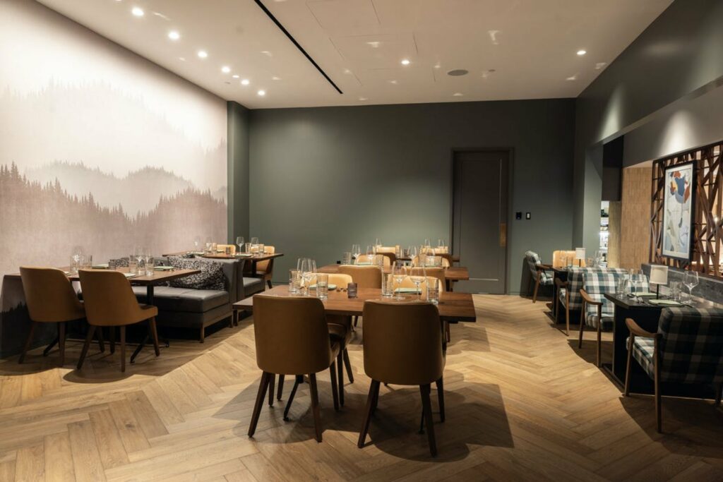 A warm and cozy private dining room with a large wall painting and wooden flooring