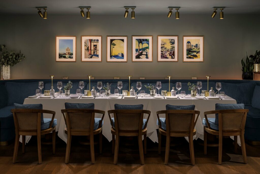 Bagatelle Miami private dining space with dimly lit lighting and blue and wooden chairs