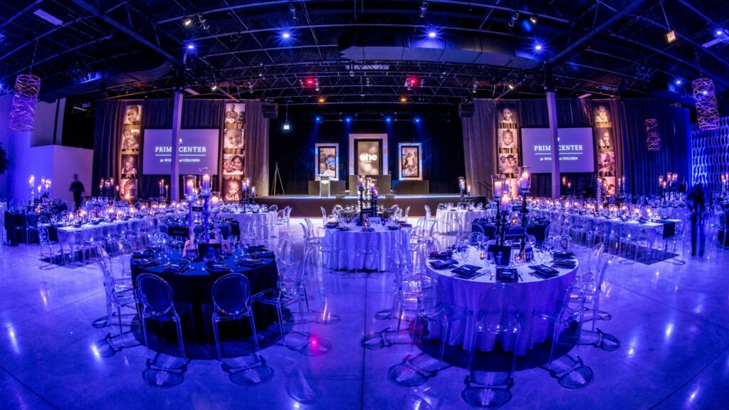 The Geraghty event space with large round tables and blue overhead lighting